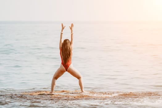 Woman sea yoga. Back view of free calm happy satisfied woman with long hair standing on top rock with yoga position against of sky by the sea. Healthy lifestyle outdoors in nature, fitness concept.