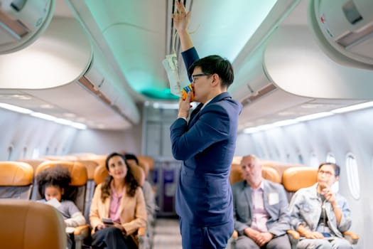 Airline staff man demonstration and explain about safety tools, oxygen mask, in the airplane to the passenger before the flight in airport area.