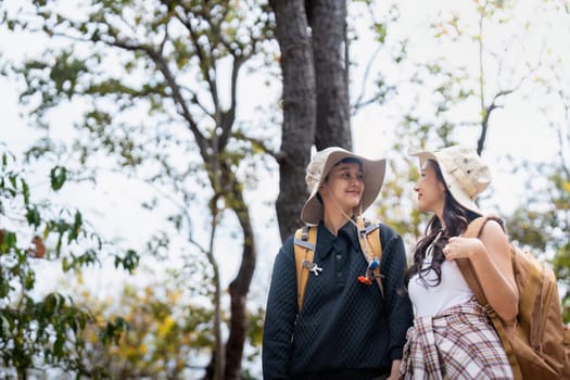 Lovely couple lesbian woman with backpack hiking in nature. Loving LGBT romantic moment in mountains.