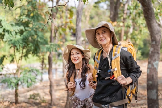 Lovely couple lesbian woman with backpack hiking in nature. Loving LGBT romantic moment in mountains.