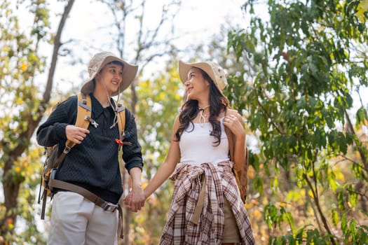 Lovely couple lesbian woman with backpack hiking in nature. Loving LGBT romantic moment in mountains.