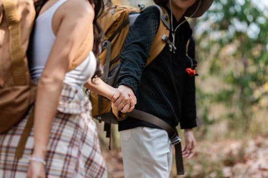 Happy LGBT Lesbian couple Travelers Hiking with Backpacks in forest Trail. LGBT Lesbian Couple Hikers with backpacks walks in mountains in vacation.