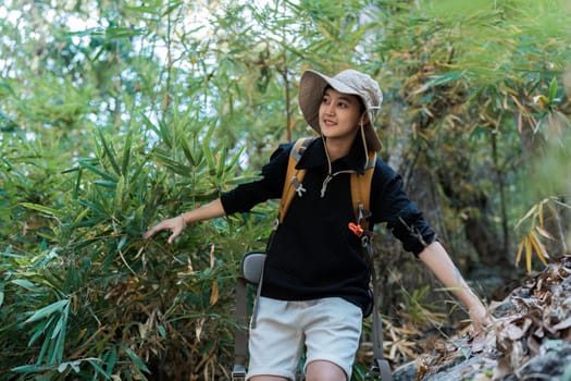 LGBTQ backpacker traveling alone in forest. Attractive male traveler walking in nature wood during holiday vacation trip.