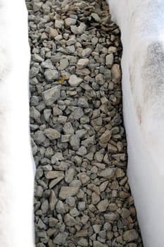 The drainage trench is covered with geotextile and filled with crushed stone to drain ground water from the site and adjacent territory