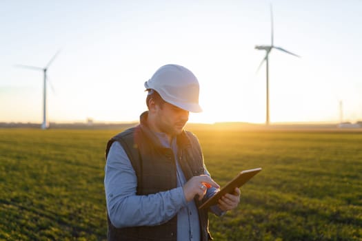 Businessman checking on wind turbine energy production.