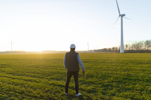 Businessman checking on wind turbine energy production.