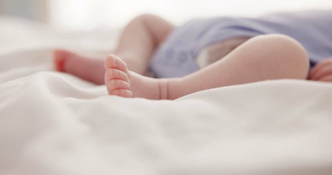 Sleeping, dreaming and feet of baby on bed for child care, resting and relax in nursery. Adorable, cute and closeup of toes of innocent newborn infant for health, wellness and development at home.
