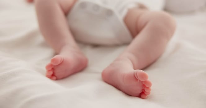 Sleeping, adorable and feet of baby on bed for child care, dreaming and relax in nursery. Family, cute and closeup of toes of innocent newborn infant for health, wellness and development at home.