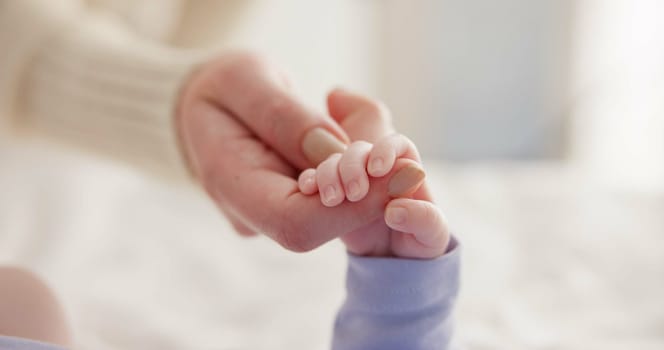 Sleeping, family and holding hands with baby on bed for bonding, love and relationship with infant. Adorable, care and closeup of parent with newborn for support, dreaming and protection at home.