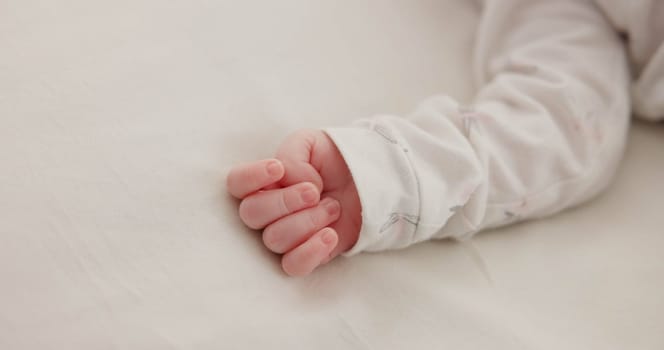 Hand, baby and sleeping on bed in nursery for child development, childcare and nurture in home. Newborn, resting or relaxing in bedroom with rest, dreaming or closeup for wellness and health in house.