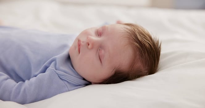 Relax, growth and sleep with a baby on a bed closeup in a home, dreaming during a nap for child development. Kids, calm and rest with an adorable newborn infant asleep in a bedroom for comfort.