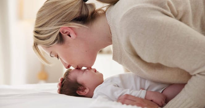 Happy, mother and baby kiss with love, care and support in a home with newborn and bonding. Morning, mom and relax infant with child security and motherhood in a family home on a bed with mama.