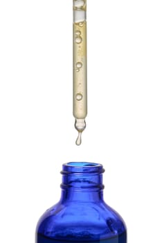 A glass blue bottle with a dropper on a white isolated background, a container for cosmetic products. 