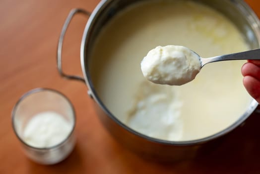 Pot with yogurt on the background, concept of homemade dairy product