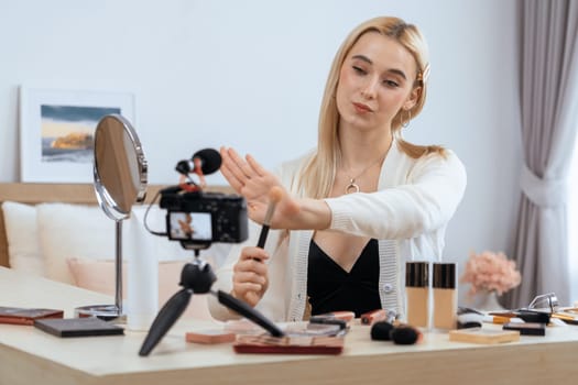 Young woman making beauty and cosmetic tutorial video content for social media. Beauty blogger smiles to camera while showing how to beauty care to audience or followers. Panorama Blithe