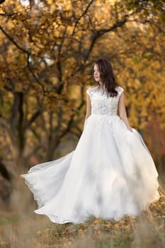 beautiful sensual bride in white wedding dress standing outdoor on natural background