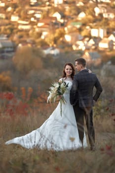 Full length body portrait of wedding couple standing outdoor on natural background