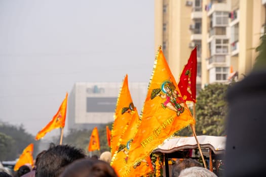 Gurgaon, Delhi, India - 22nd Jan 2024: Crowd of people walking on Shobha yatra walk carrying flag celebrating the Pran Pratishtha consecration of Ram mandir temple massive celebration in India