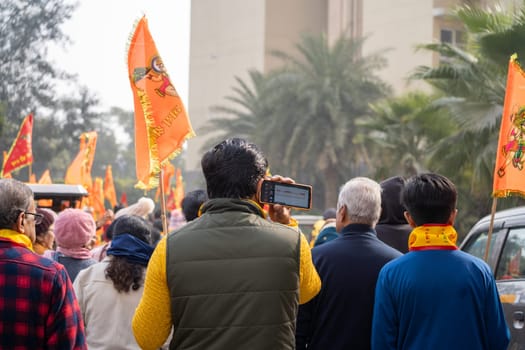 Ayodhya, Uttar Pradesh, India - 22nd Jan 2024: Crowd of people walking on Shobha yatra walk carrying flag celebrating the Pran Pratishtha consecration of Ram mandir temple massive celebration in India