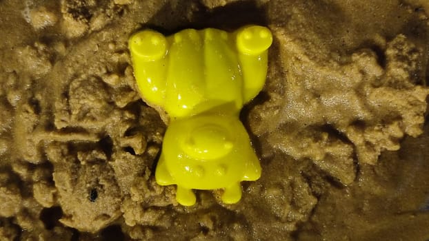 yellow plastic toy lies in the sand, children's toy, object, beach. High quality photo