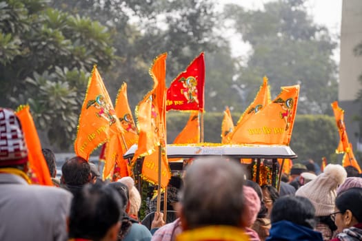 Ayodhya, Uttar Pradesh, India - 22nd Jan 2024: Crowd of people walking on Shobha yatra walk carrying flag celebrating the Pran Pratishtha consecration of Ram mandir temple massive celebration in India