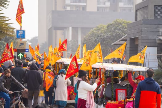 Ayodhya, Uttar Pradesh, India - 22nd Jan 2024: Huge crowd of hindu devotees walking along holding flag celebrating the Pran Pratishtha consecration of Ram mandir temple massive celebration in India