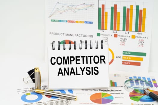 Business concept. On the table are reports with graphs and a notepad with the inscription - Competitor Analysis