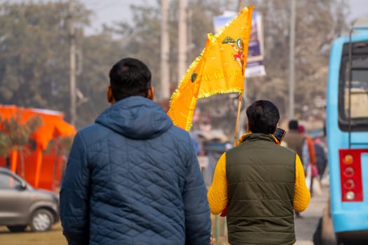 Ayodhya, Uttar Pradesh, India - 22nd Jan 2024: hindu devotee celebrating and carrying the flag celebrating the Pran Pratishtha consecration of Ram mandir temple massive celebration in India