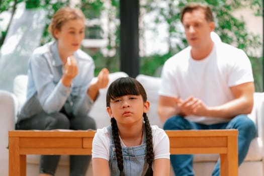 Stressed and unhappy young girl crying and trapped in middle of tension by her parent argument in living room. Unhealthy domestic lifestyle and traumatic childhood develop to depression. Synchronos