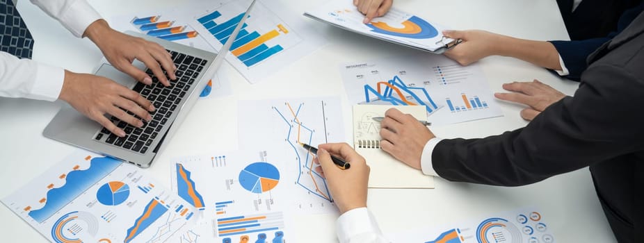 Business people in group meeting in formal attire share idea discussing report for company profit in creative workspace for start up business shot in close up view on group meeting table . Oratory .