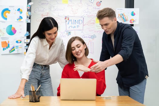 Professional business team working together by using laptop in start up project at meeting in front of glass board with mind map while colleague brainstorm and discuss about strategy. Immaculate.