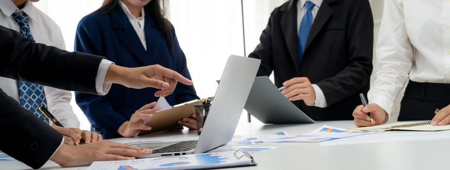 Business people in group meeting in formal attire share idea discussing report for company profit in creative workspace for start up business shot in close up view on group meeting table . Oratory .