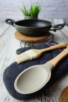 wooden cutlery fork and spoon and cooking pan on table .