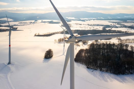 Wind turbines in the field against mountains at sunset