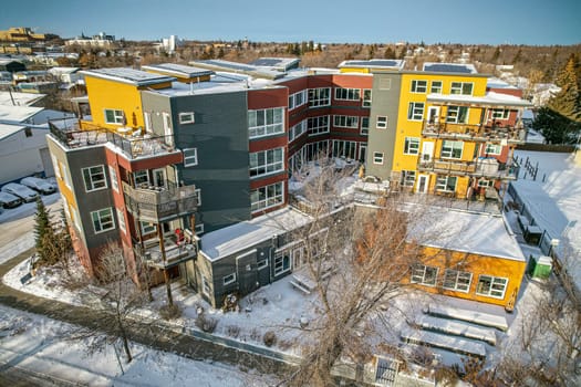 Drone image capturing the charm of Riversdale neighborhood in Saskatoon during the winter season, with its snow-covered streets, historic buildings, and cozy atmosphere