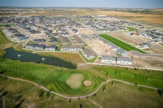 Drone image capturing the town of Warman in Saskatchewan during the summer season, highlighting its suburban and residential areas surrounded by lush greenery and vibrant atmosphere