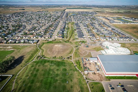 Drone image capturing the town of Warman in Saskatchewan during the summer season, highlighting its suburban and residential areas surrounded by lush greenery and vibrant atmosphere