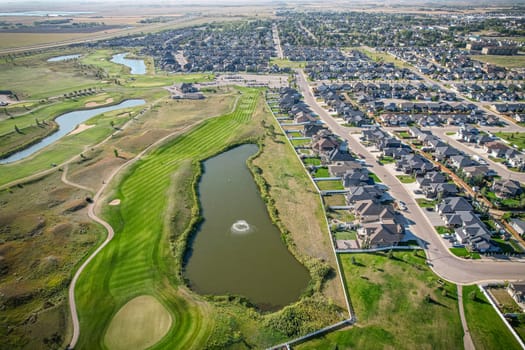 Drone image capturing the town of Warman in Saskatchewan during the summer season, highlighting its suburban and residential areas surrounded by lush greenery and vibrant atmosphere