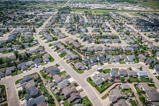 Drone image capturing the town of Warman in Saskatchewan during the summer season, highlighting its suburban and residential areas surrounded by lush greenery and vibrant atmosphere