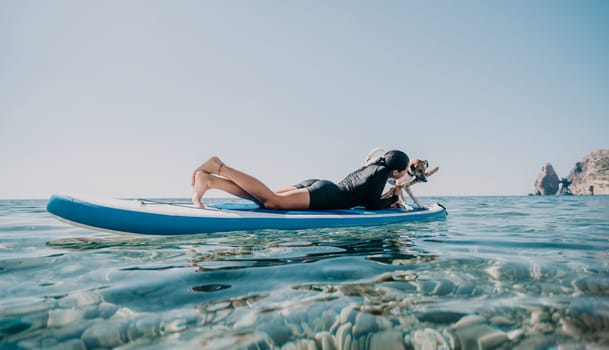 Sea woman sup. A happy positive woman in hat with family relaxing in sea, aerial back view of family on SUP board floating on calm water. Active lifestyle at sea. Summer vacation. Slow motion