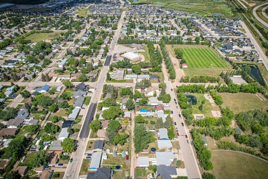 Drone image capturing the town of Warman in Saskatchewan during the summer season, highlighting its suburban and residential areas surrounded by lush greenery and vibrant atmosphere