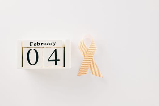 Pink awareness ribbon sign and Calender 4 February of World Cancer Day campaign isolated on white background with copy space, concept of medical and health care support