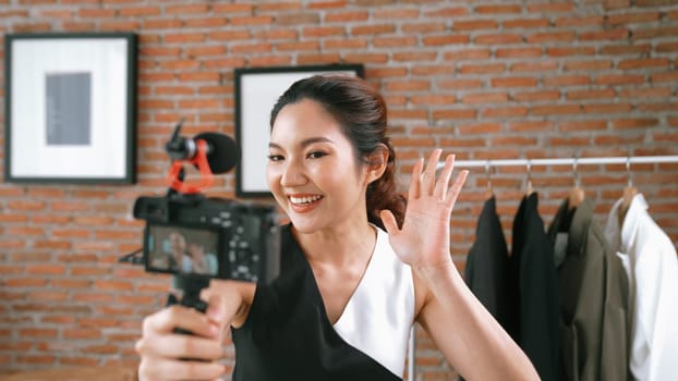 Woman influencer shoot live streaming vlog video review clothes social media or blog. Happy young girl with apparel vivancy studio lighting for marketing recording session broadcasting online.