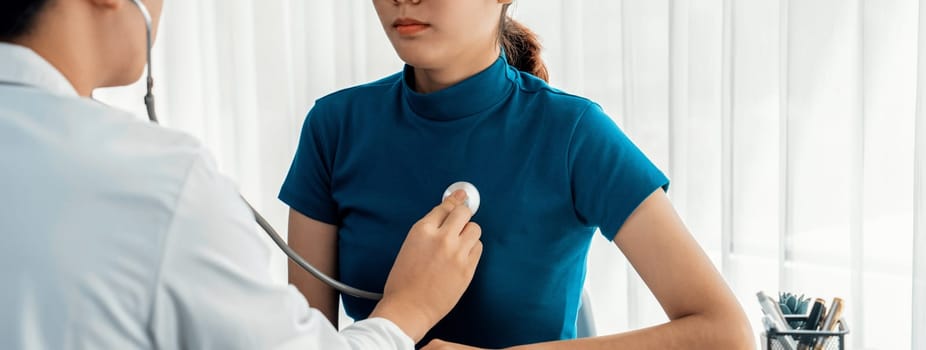 Patient attend doctor's appointment at clinic or hospital office. Doctor examining and diagnosis symptoms while checking the patient's pulse with stethoscope. Panorama Rigid