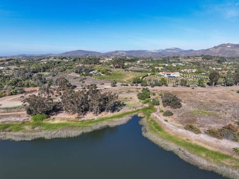 Aerial view over water reservoir and a large dam that holds water. Rancho Santa Fe in San Diego, California, USA