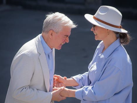 Stylish elderly laughing couple on a walk. Romantic relationships of mature people