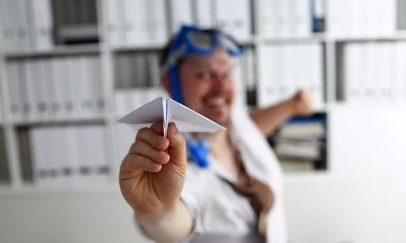 Man wearing suit and tie in goggles and snorkel play with fly paper plane in office closeup. Count days to leave annual day off workaholic freedom fun tourism resort idea ticket sale overseas concept