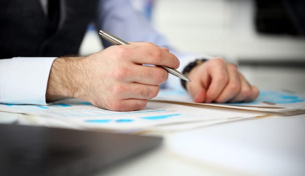 Clerk man at office workplace with silver pen in arms do paperwork closeup. Staff dress code worker job offer client visit study profession boss market idea coach training
