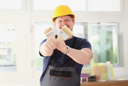 Arm of smiling worker hold brush closeup. Manual job workplace DIY inspiration improvement fix shop yellow helmet hard hat joinery startup idea industrial education profession career concept