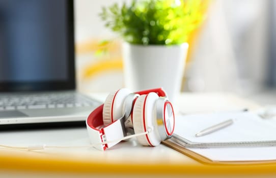 Empty remote office workplace with laptop pc and headset closeup. Receptionist or secretary of contact data center desktop keyboard device desk table ip telephony or callcenter voice message system